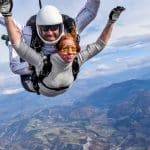 Duo en tandem en chute libre, passagère aux lunettes jaunes