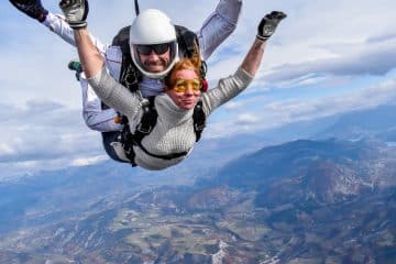 Duo en tandem en chute libre, passagère aux lunettes jaunes